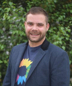 Herr Wolfram Haesler lächelt in die Kamera. Er trägt ein Jacket und ein T-Shirt